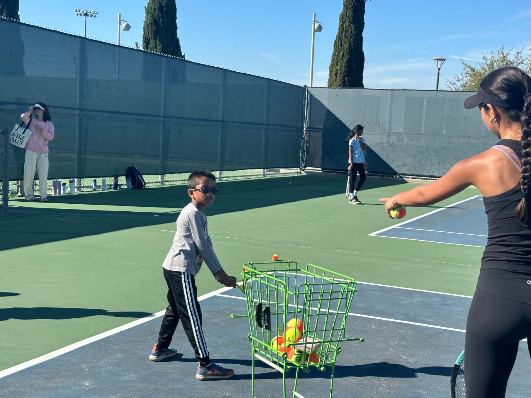 coach feeding balls to a kid